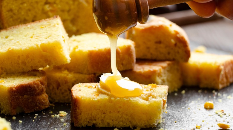 Closeup view at sweet honey butter homemade cornbread slices on kitchen table