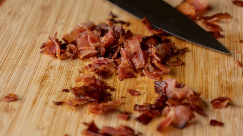 Chopped crispy bacon on wooden board
