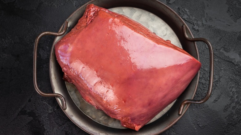whole uncooked beef liver in cast iron pan