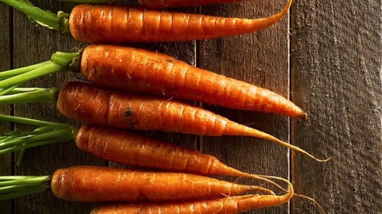 raw carrots on wooden board
