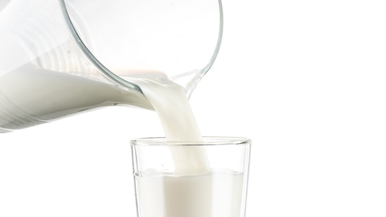 whole milk is poured from a pitcher