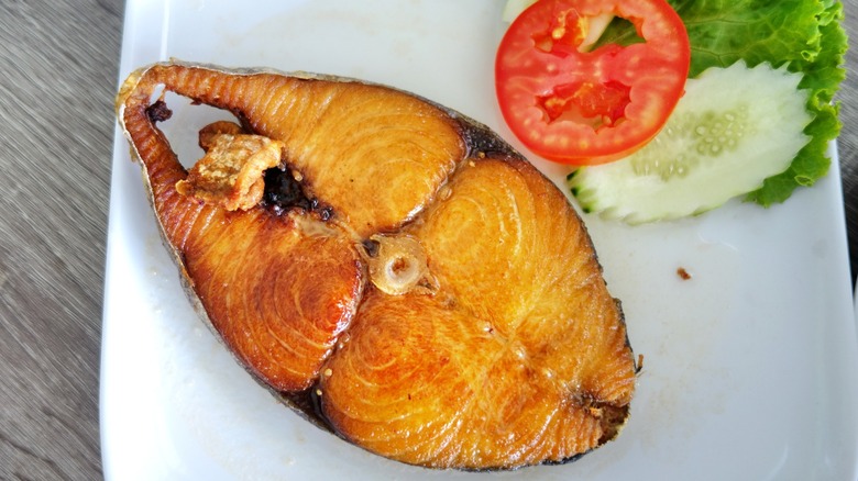 filet of king mackarel with salad on plate