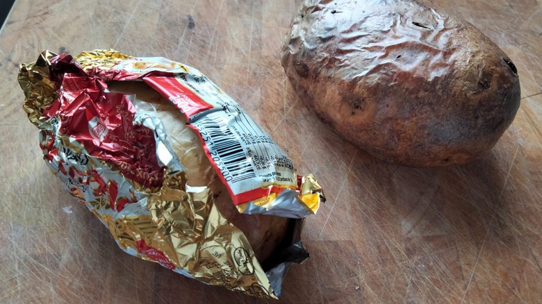A wrapped and unwrapped baked potato, side by side