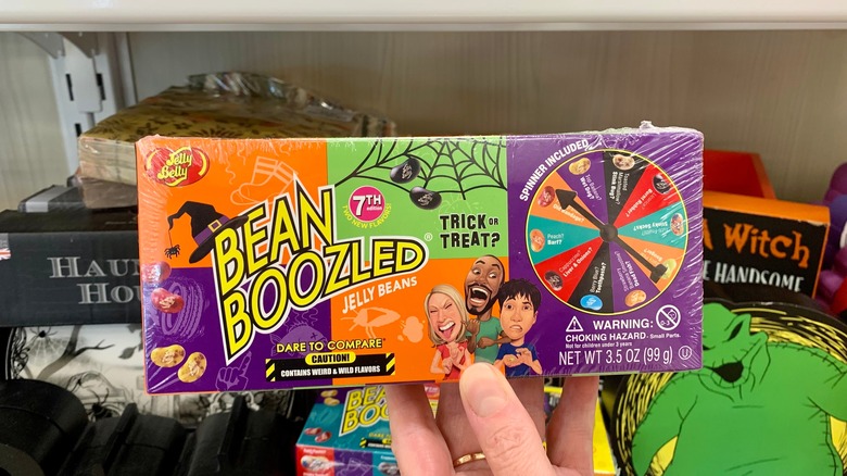 A hand holding Jelly Belly Halloween theme bean boozled trick or treat weird and wild flavors with a spinner.