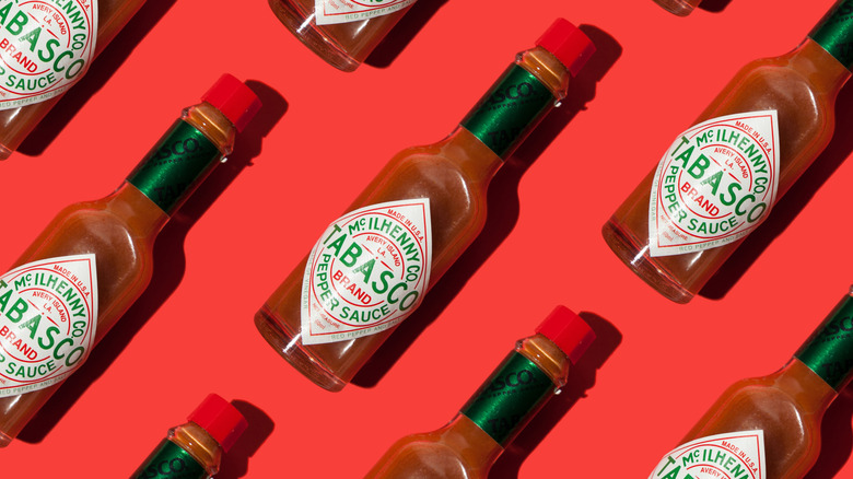 Bottles of Tabasco sauce on a red background