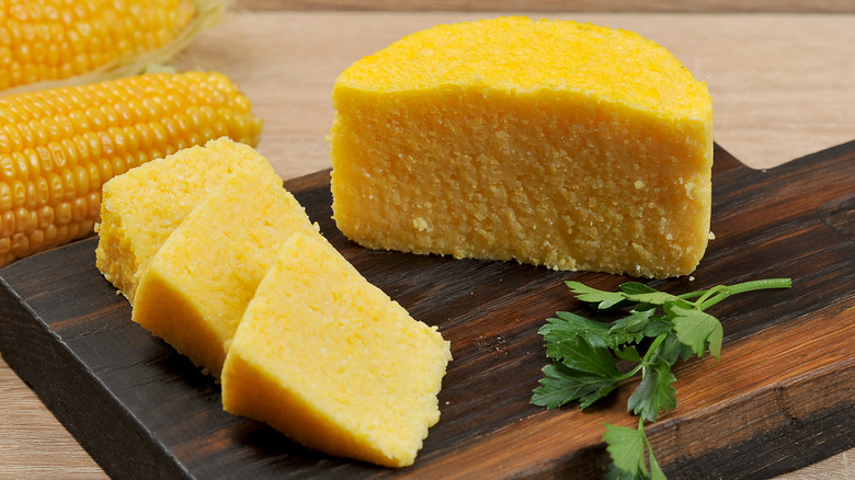 Pieces of yellow hominy on a wooden board