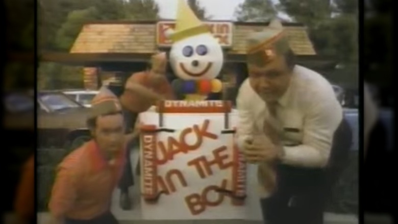 Still from 1980s commercial showing characters preparing Jack in the Box mascot for explosion