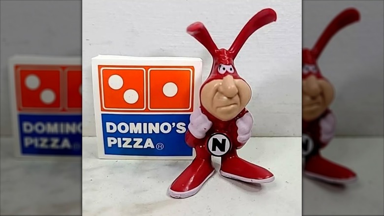 plastic noid figurine near domino's pizza logo