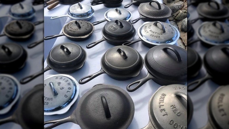 A display of cast iron skillets and lids