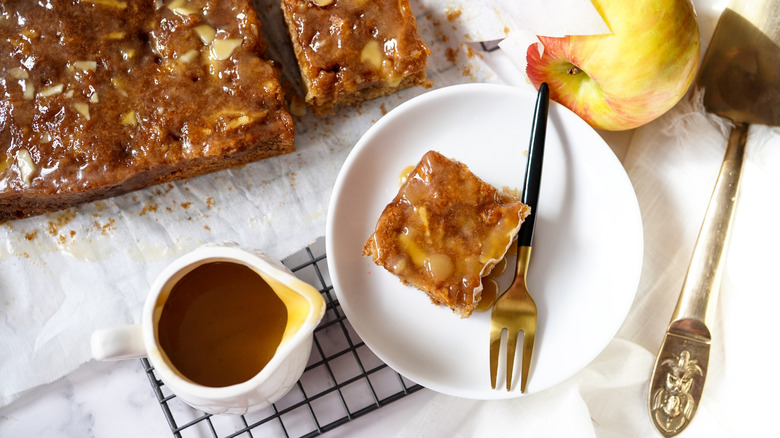 Sticky pudding topped with butterscotch sauce on plate with fork.