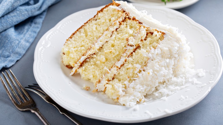 fluffy slice of coconut cream cake on plate