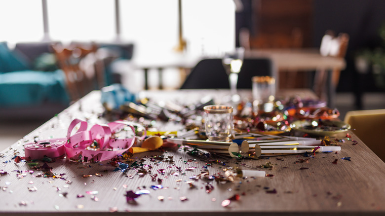 Close up of messy table with confetti, ribbons, party supplies