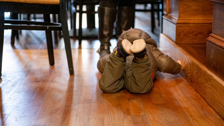 Toddler in jacket having temper tantrum in restaurant