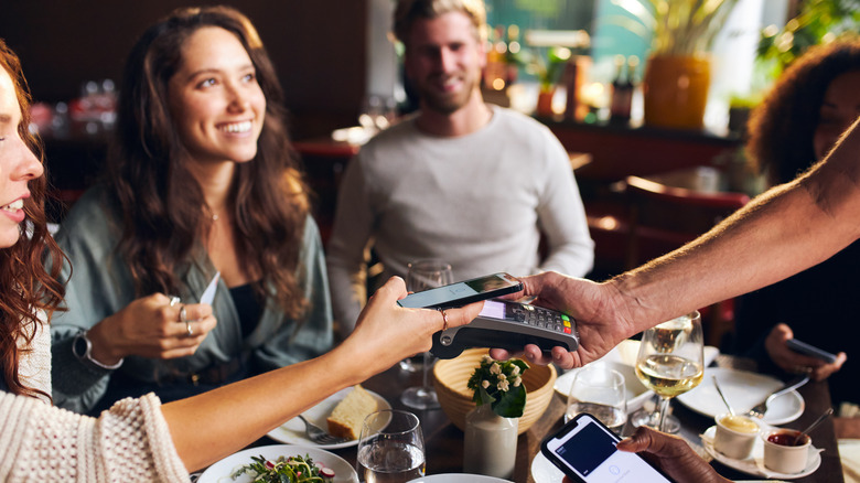 people paying contactlessly at restaurant