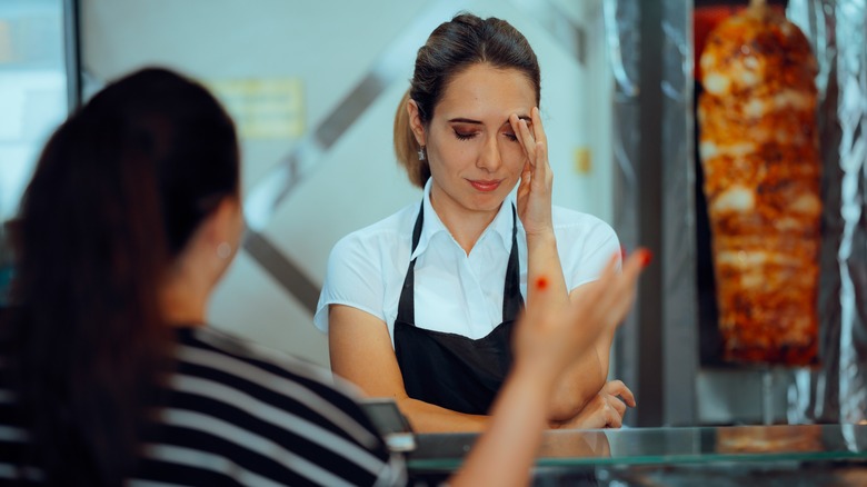 Angry client reproaches upset looking restaurant manager