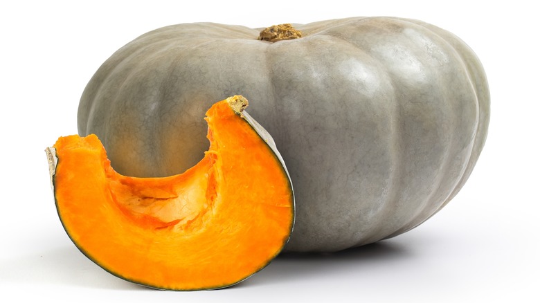 A whole Jarrahdale winter squash with a single slice next to it