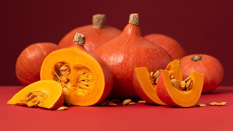 Whole and sliced red kuri squashes