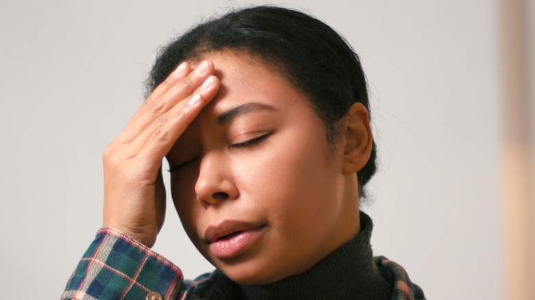 Woman touching her temple during a migraine headache