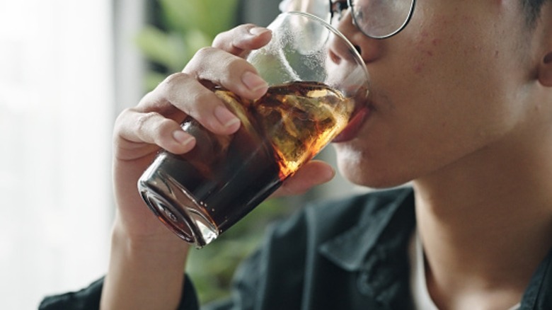 Close up of someone drinking soda from a glass