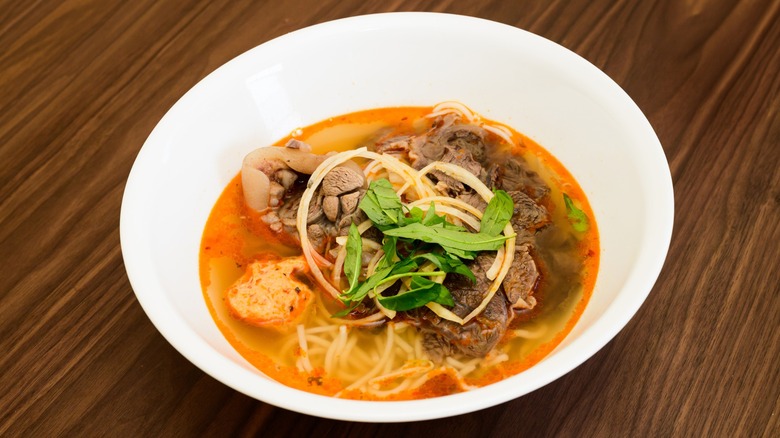vibrant red bun bo hue with beef and noodles