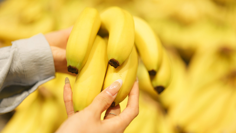 Woman holding bananas in a supermarket