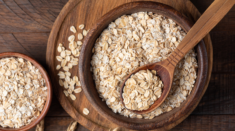 Rolled oats, oat flakes in a wooden bowl