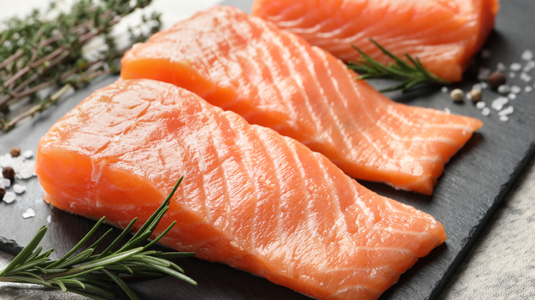 Fresh raw salmon and ingredients for marinade on light grey table