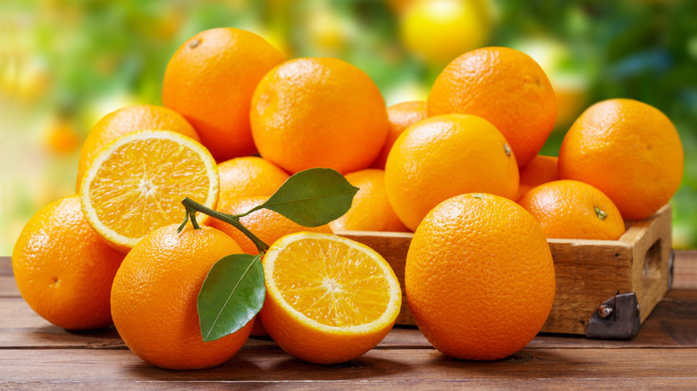 Fresh oranges, whole and sliced, on a table