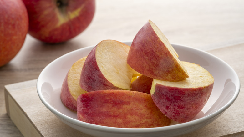 Fresh red apples sliced in white plate