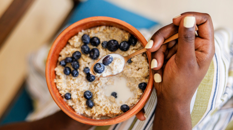 Woman eating oatmeal with blueberries