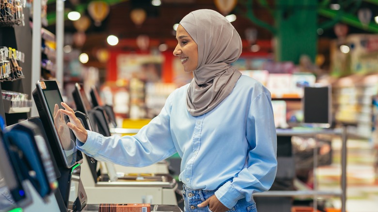 woman using self checkout register