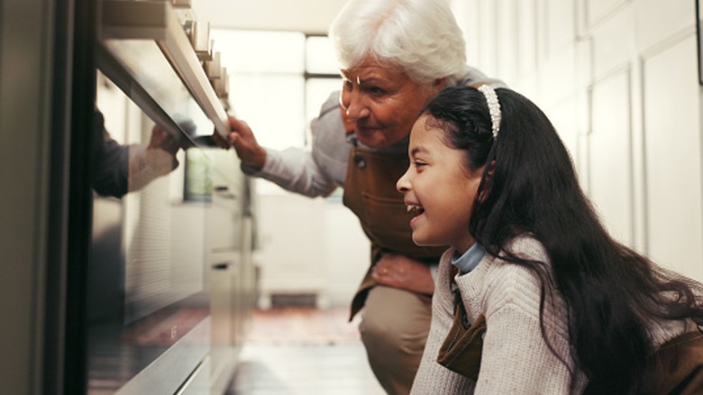 woman and child check an oven
