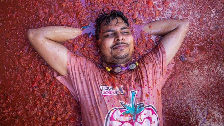 Man laying in a sea of tomatoes