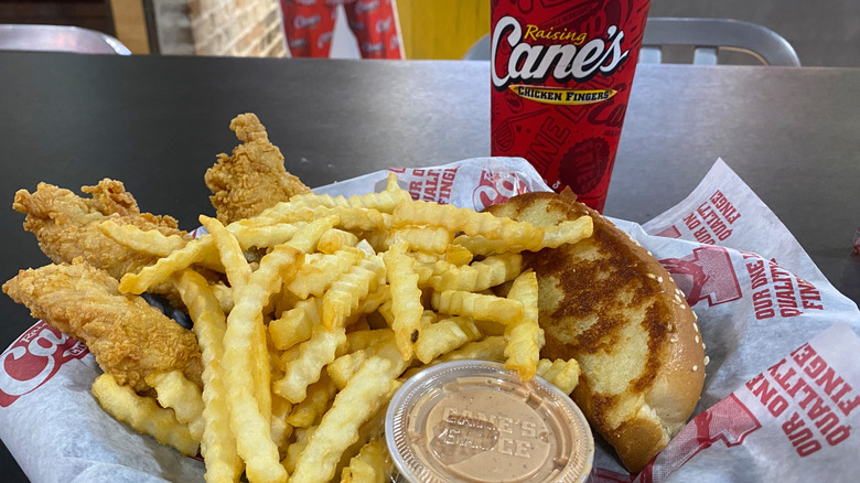 Closeup of Raising Cane's meal with fries and chicken fingers.