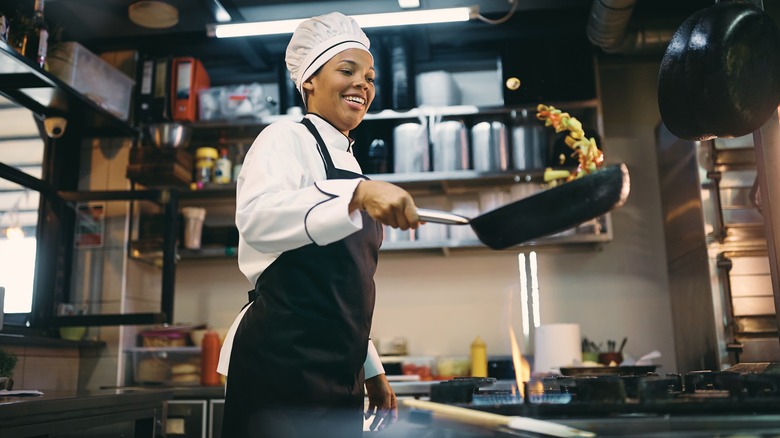 Chef flipping food in a pan