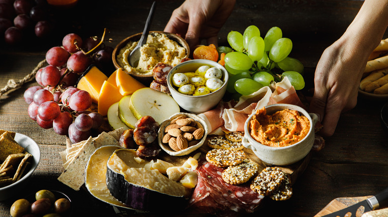 Hands serving a cheese tray