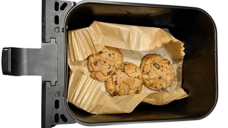 Cookies partially covered by parchment paper in an air fryer