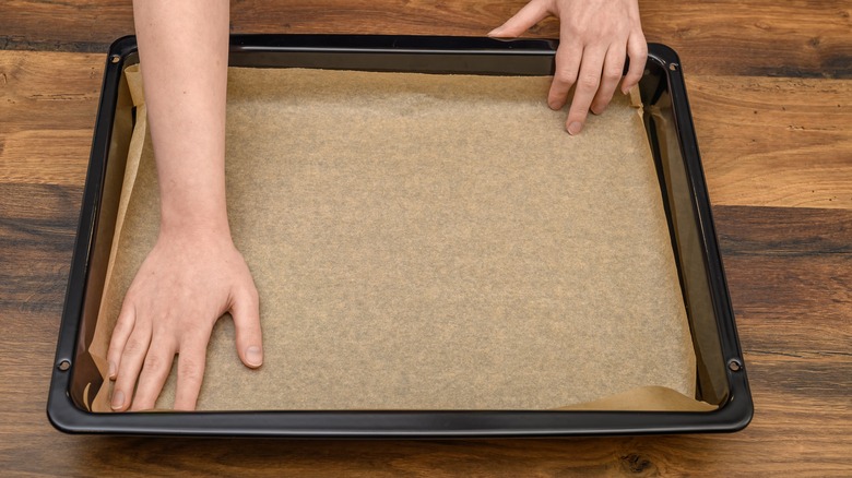 Lining a baking tray with parchment paper