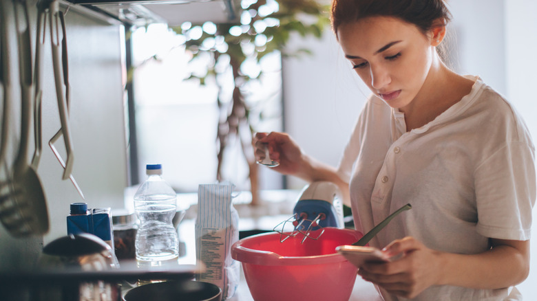woman looking closely at recipe 