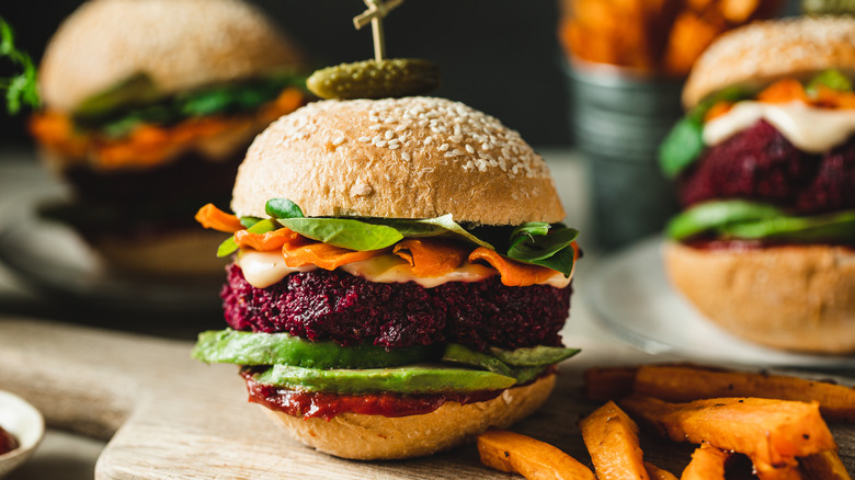 Three vegetarian burgers on a serving table.