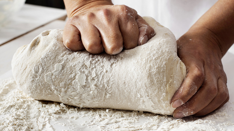 hands kneading bread dough
