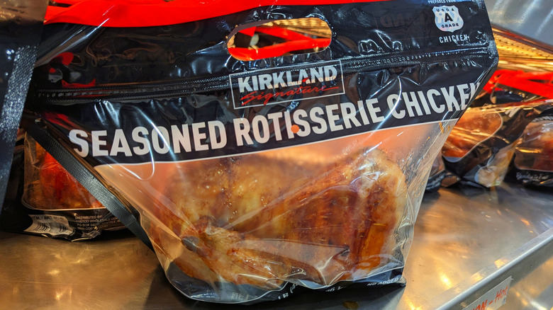 A close-up of a Costco rotisserie chicken in a bag on a display unit