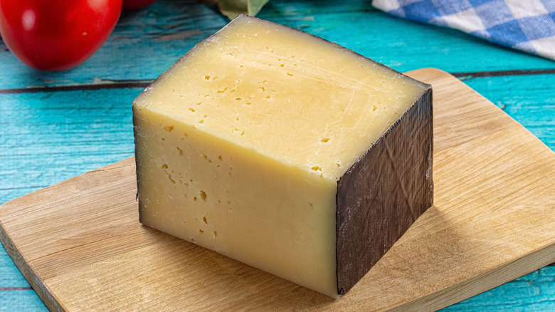 A square of hard cheese on a board
