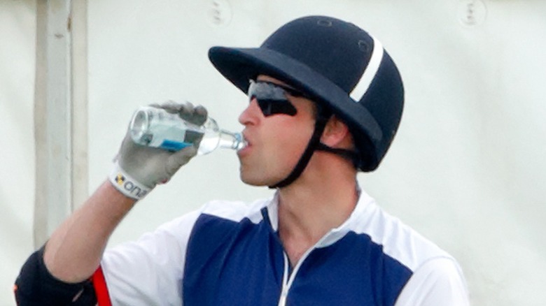 Prince William drinking from a water bottle during polo