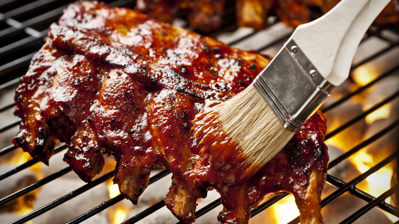 Rack of ribs being brushed with marinade