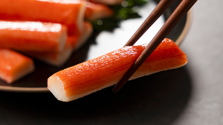 Imitation crab held between chopsticks