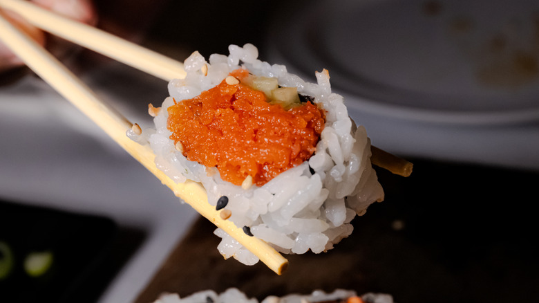 Close-up of chopsticks holding a spicy tuna roll
