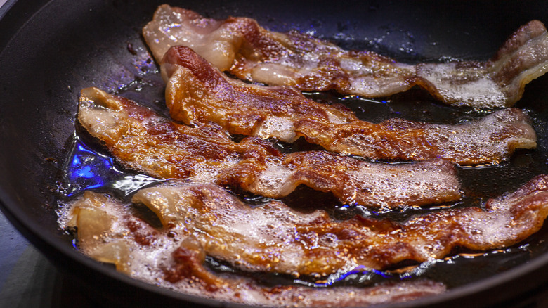 bacon cooking in frying pan