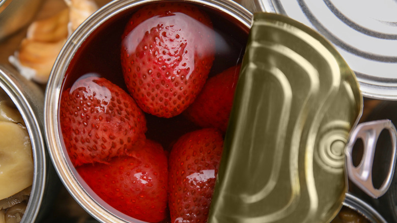 A close-up of an open can of strawberries