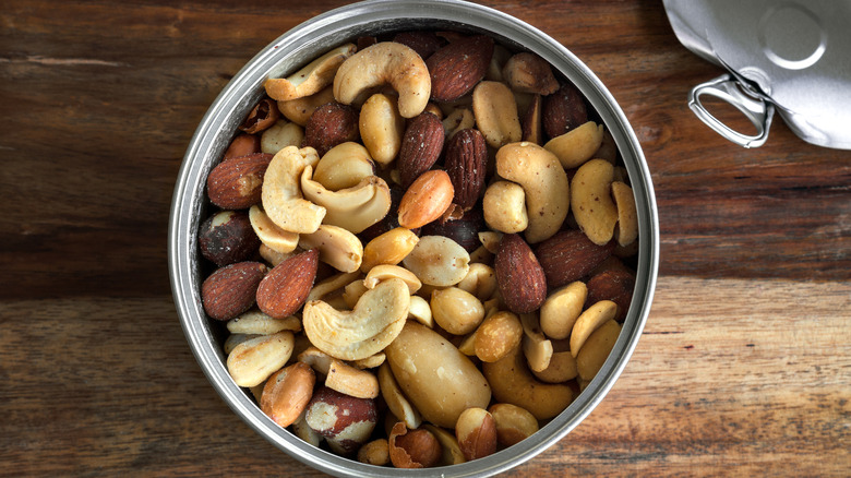 A top-down view of a can of mixed nuts on a wooden table